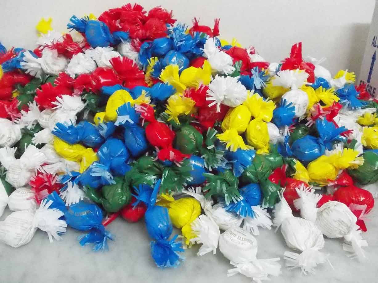 Mucchio di caramelle incartate colorate su marmo bianco