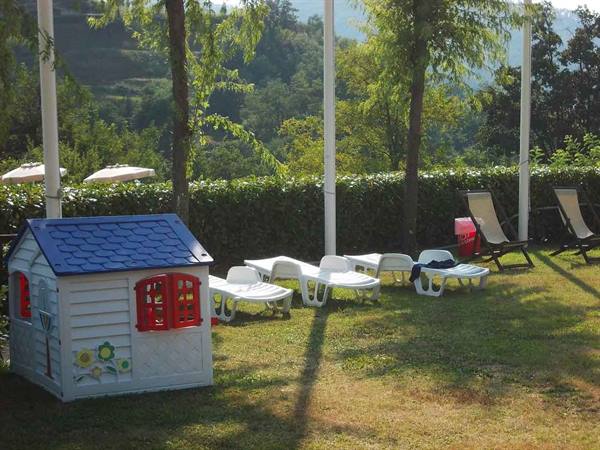 White toy playhouse and plastic loungers on sunny lawn