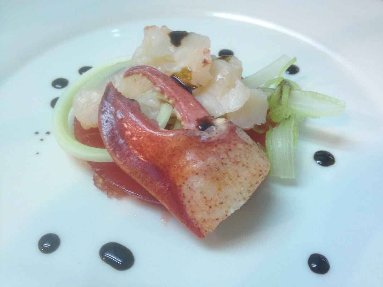 Pinza di astice su pomodoro e sedano con gocce di riduzione al balsamico