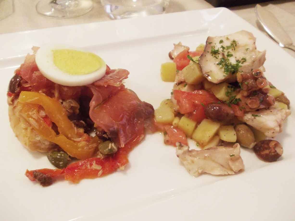 Piattino bianco con prosciutto, uovo sodo e insalata di polpo e patate