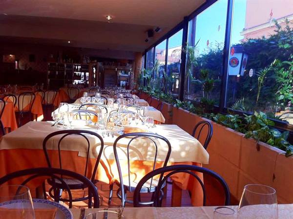 Restaurant dining room with set tables, orange tablecloths and bentwood chairs