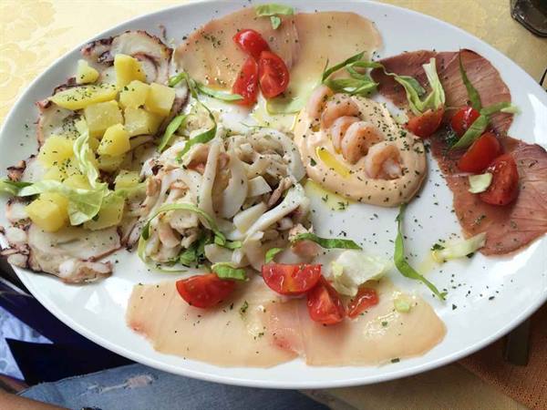 Seafood appetizer platter: octopus with potatoes, squid, shrimp and carpaccio