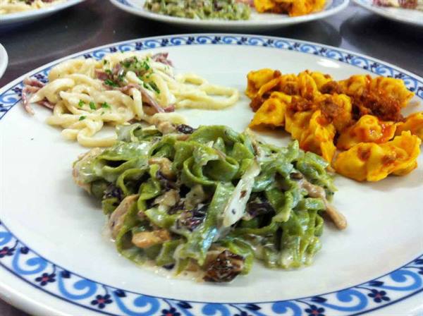 Plate with green pappardelle with mushrooms, tagliatelle and ravioli in sauce