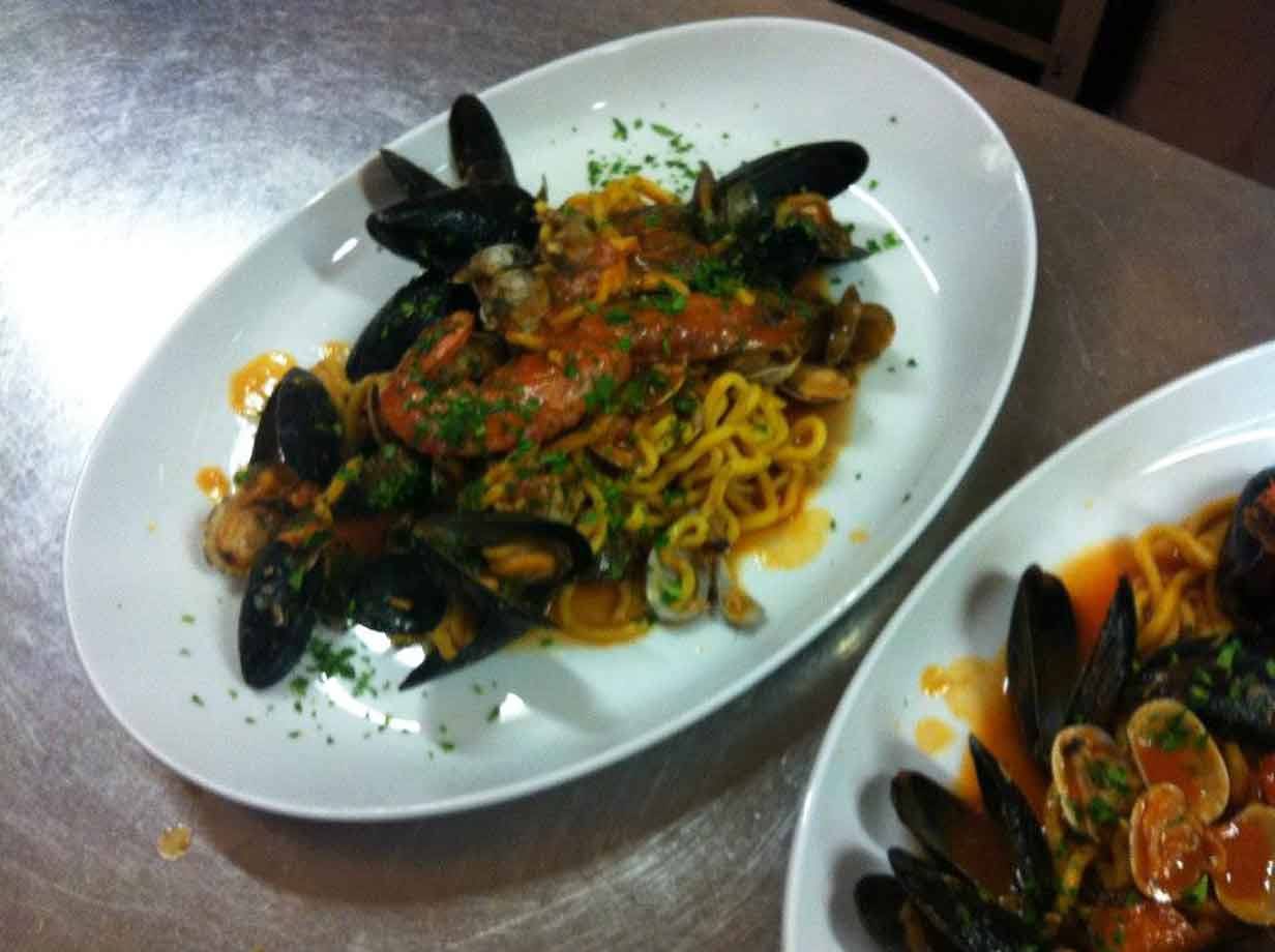 Piatto di spaghetti ai frutti di mare con cozze e vongole, prezzemolo verde