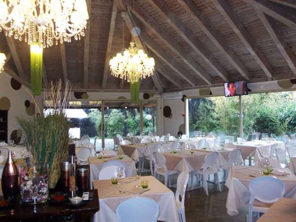 Restaurant dining room with set tables, white chairs and crystal chandeliers