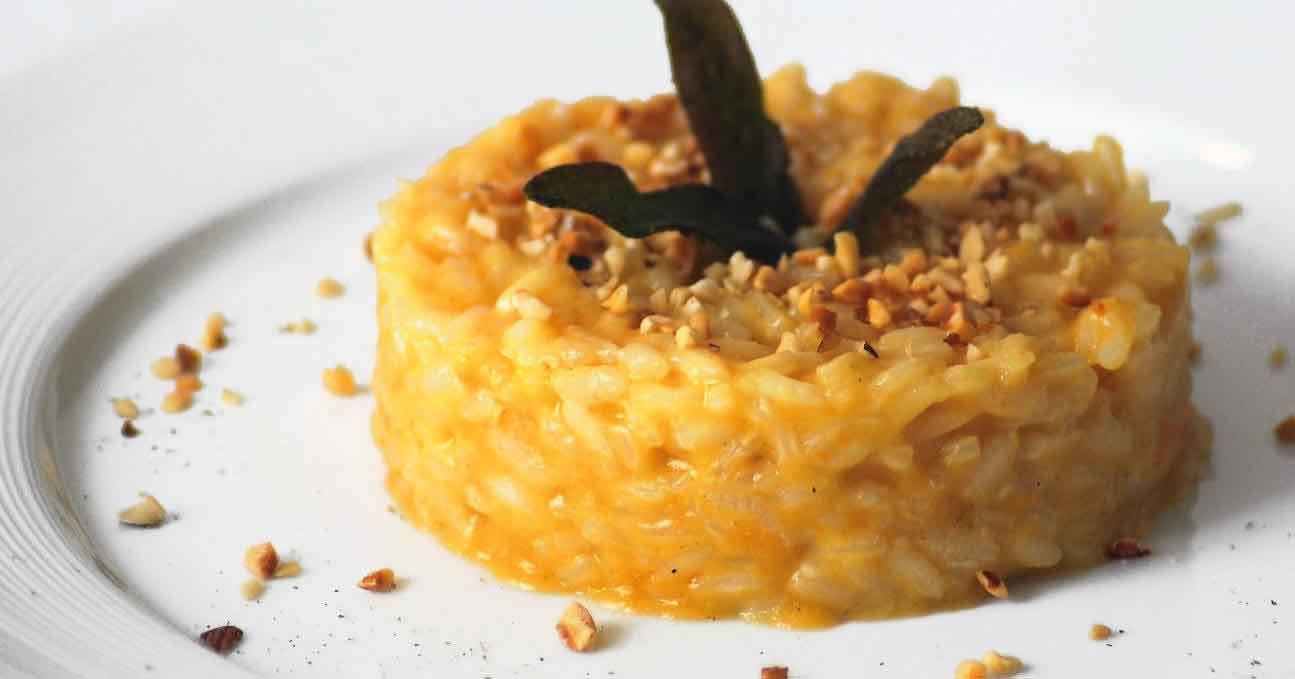 Tortino di riso zucca e nocciole con salvia su piatto bianco