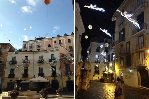 Old buildings with hanging Christmas lights: illuminated angels by day and night