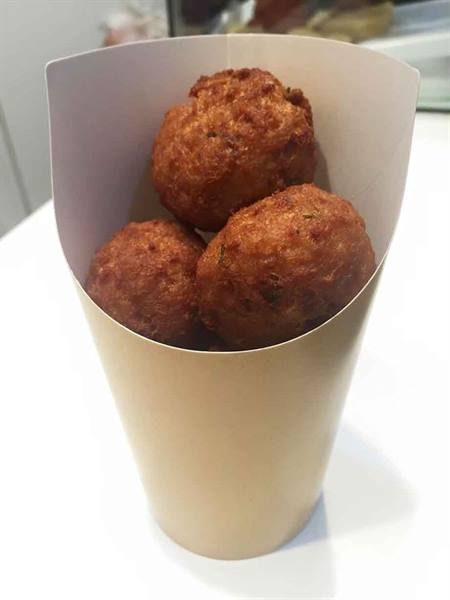 Golden cod fritters in a white paper cone