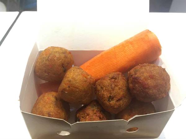 Fried fritters with carrot in a paper box, natural light