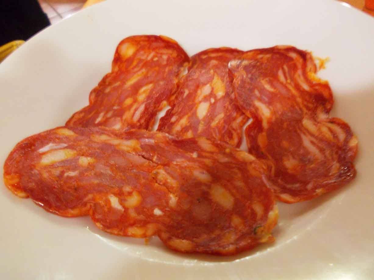 Fette di salame con grasso marmorizzato servite su un piatto bianco