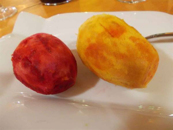 Two peeled prickly pears, red and yellow, on a white plate