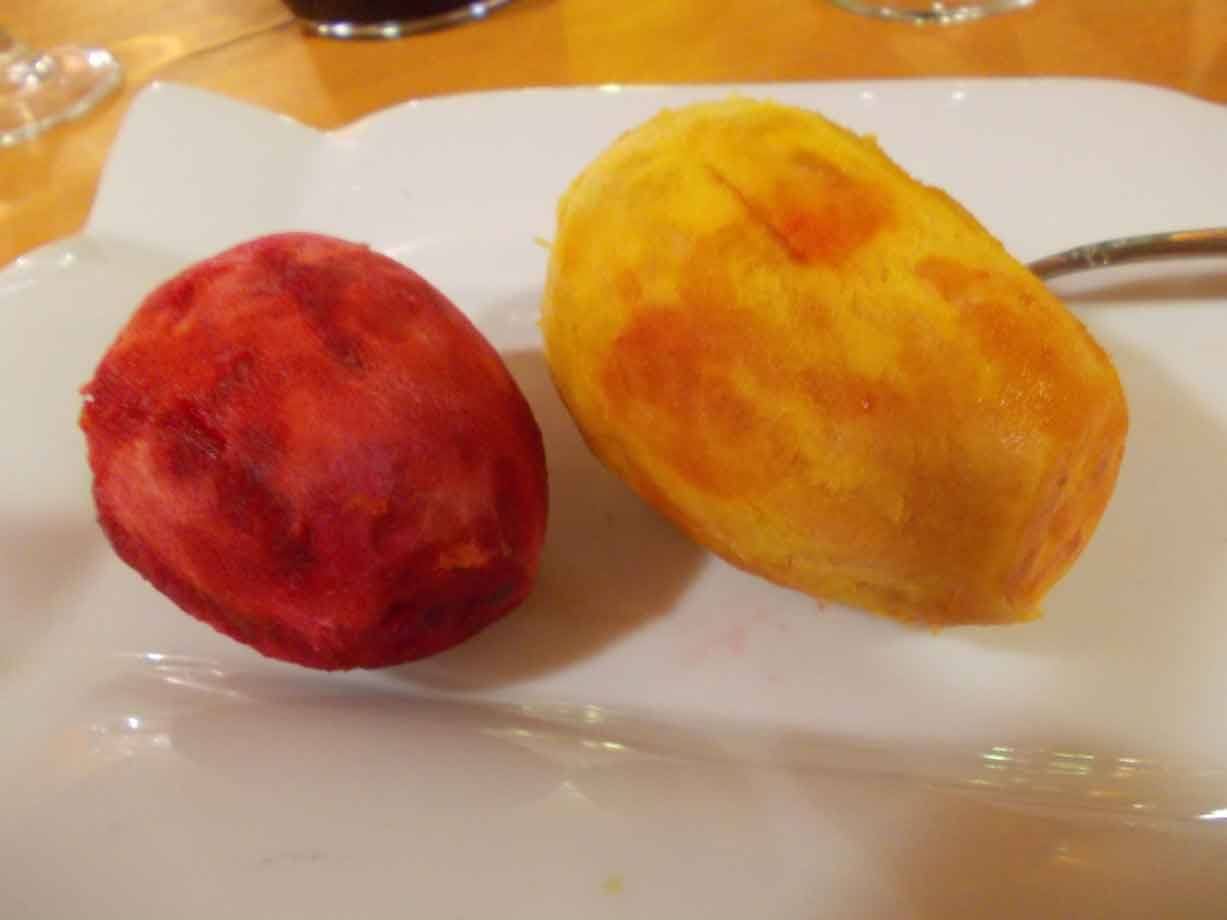 Due fichi d'India pelati, rosso e giallo, su un piatto bianco