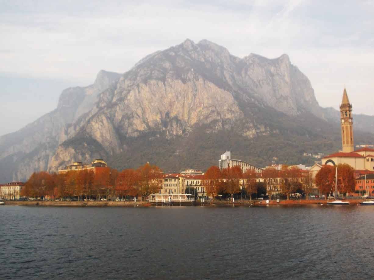 Lungolago di Lecco autunnale sotto il Resegone, campanile e alberi rossi