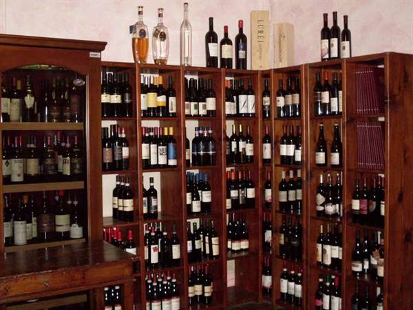 Wine cellar with wooden shelves full of wine and liquor bottles