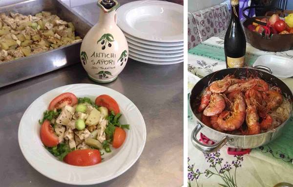Octopus salad with tomatoes and a pot of large prawns on a set table