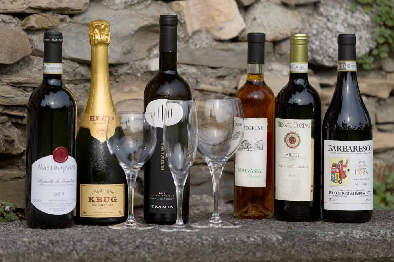 Bottiglie di vino e spumante Krug con calici vuoti su pietra