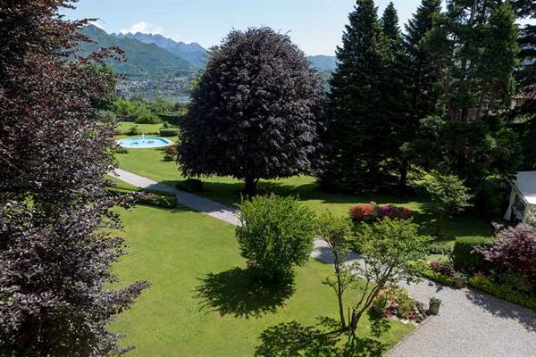 Garden with lawns, copper beeches and pool, lake and mountains beyond