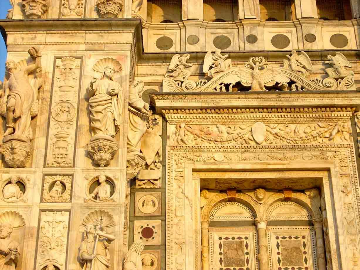 Facciata marmorea della Certosa di Pavia, statue e rilievi nella luce dorata