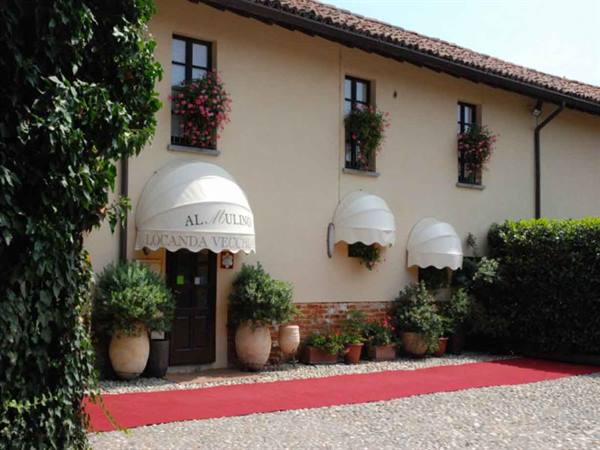 Al Mulino facade with white awnings, window flowers and red carpet