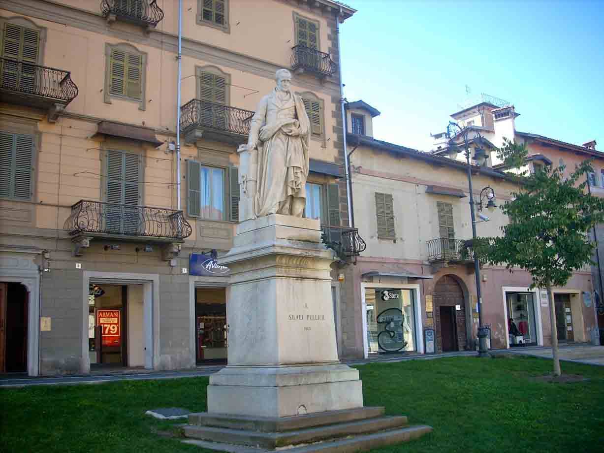 Statua in marmo di Silvio Pellico su piedistallo, piazza con edifici storici