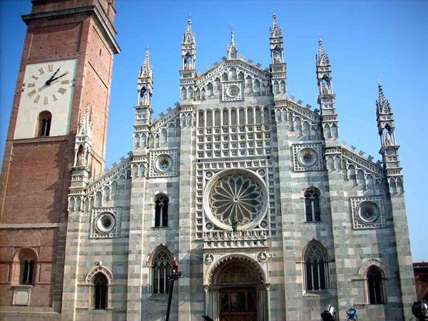 Marble facade of Monza Cathedral with rose window and brick bell tower