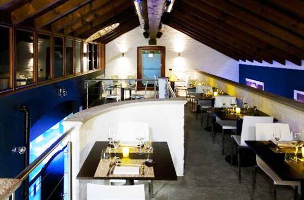Restaurant dining room with wooden beams, set tables and lit candles