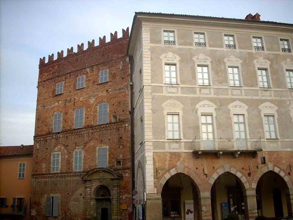 Brick crenellated palace beside a light building with arched porticoes