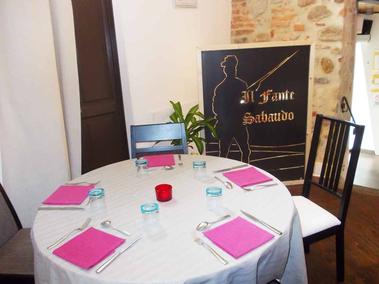 Tavola apparecchiata con tovaglia bianca e tovaglioli rosa al ristorante Il Fante Sabaudo