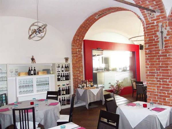 Restaurant dining room with brick vaults, set tables and wine bottles