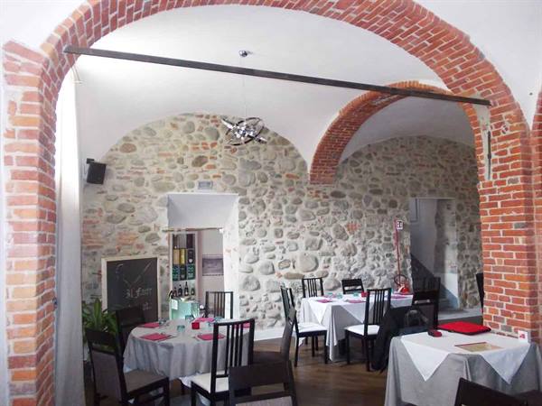 Restaurant dining room with red brick arches and exposed stone walls