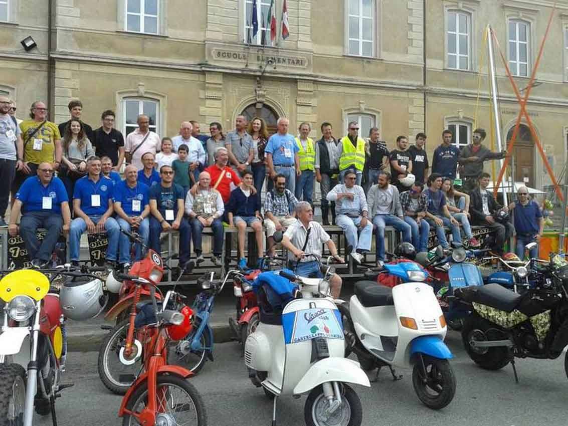 Gruppo di radunanti con moto e scooter d'epoca davanti alla scuola elementare