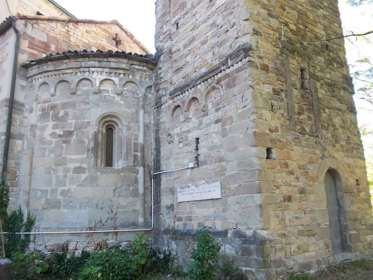 Abside romanica in pietra e campanile con bifore della Pieve di Rivalta