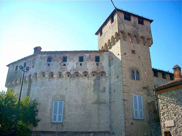Ancient stone castle with crenellated tower and corbels, lit by sunlight