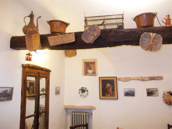 Wooden beam with copper pots, wicker baskets and birdcage, rustic interior