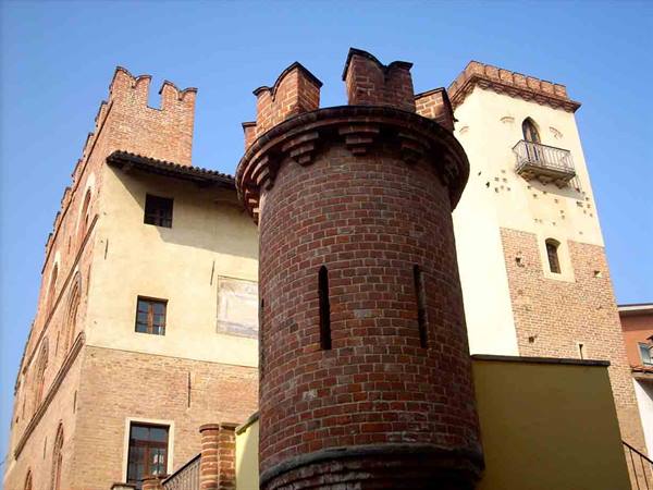 Red brick Comentina tower in front of medieval buildings in Asti