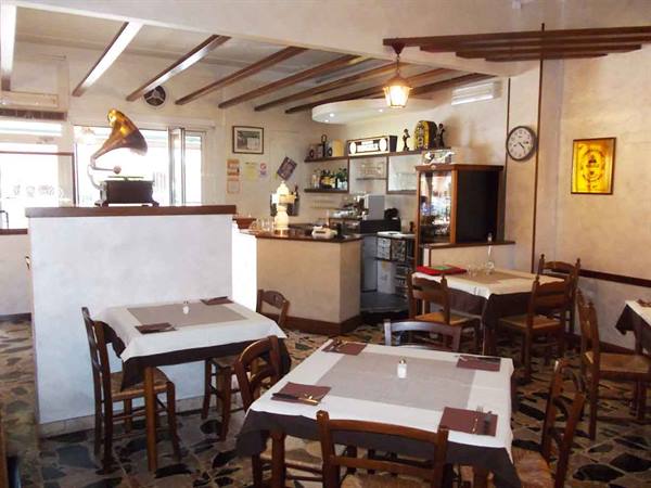Dining room with set tables, vintage gramophone and counter with espresso machine
