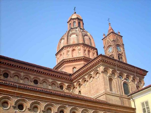 Brick church dome and clock bell tower under a blue sky