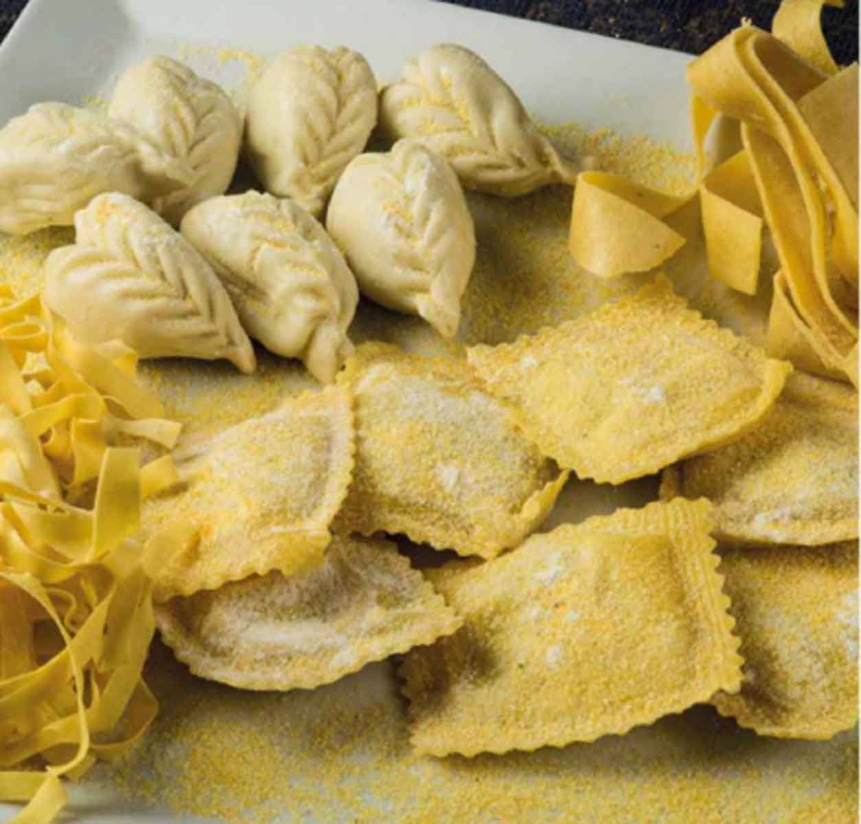 Pasta fresca fatta a mano: ravioli, tortelli a foglia e tagliatelle su vassoio bianco
