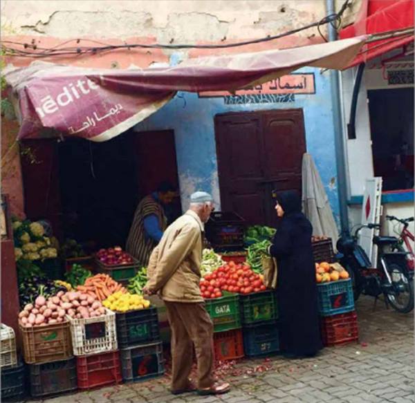 Elderly man buying vegetables at a street market stall in Marrakech