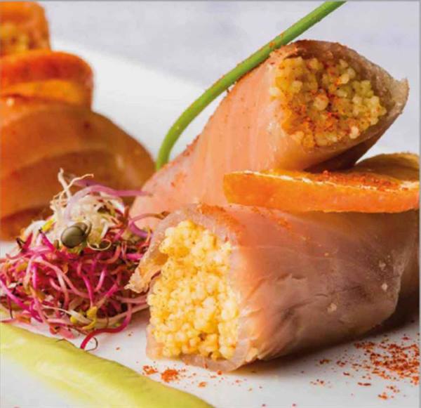 Salmon rolls stuffed with couscous, sprouts and orange slices