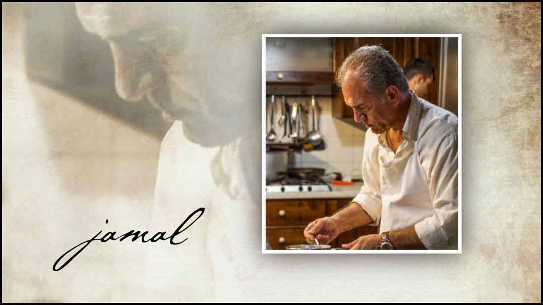 Lo chef Jamal impiatta in cucina, luce calda, pentole appese