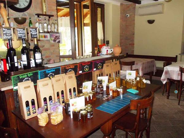 Wooden table with wine gift packs, honey jars and Grado Kilo sign