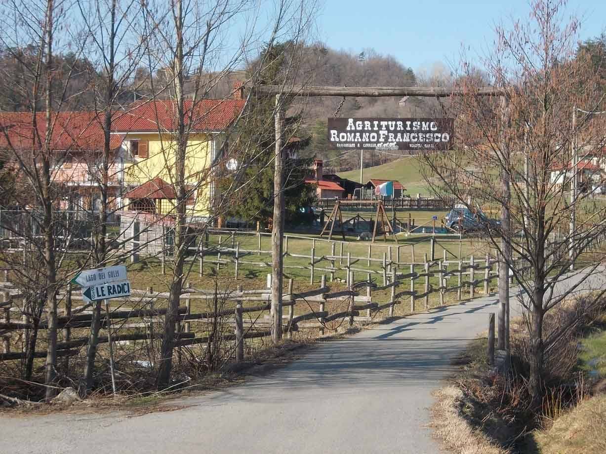 Ingresso dell'agriturismo Romano Francesco, recinzione in legno lungo la strada sterrata