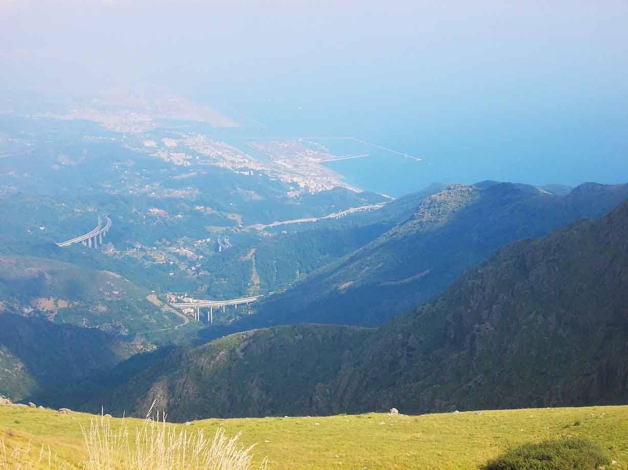 Autostrada con viadotti tra monti verdi verso la costa e il mare