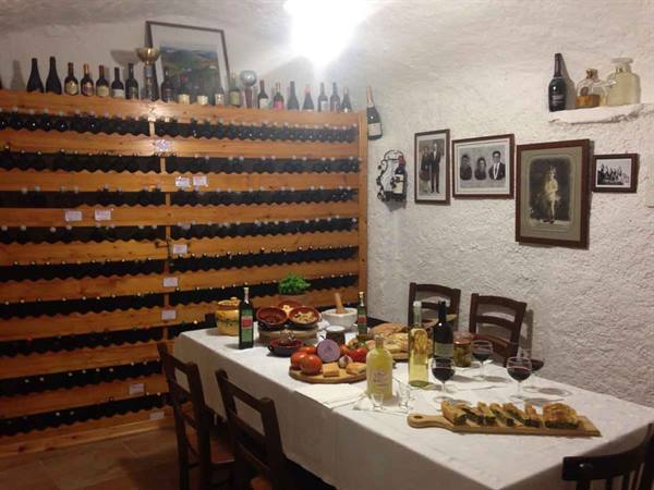 Wine cellar with bottles on wooden racks and a set dinner table