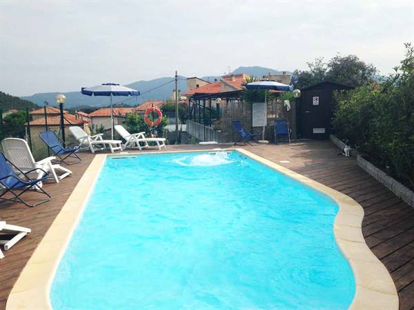 Turquoise pool on wooden deck with loungers and blue umbrellas, Country Village