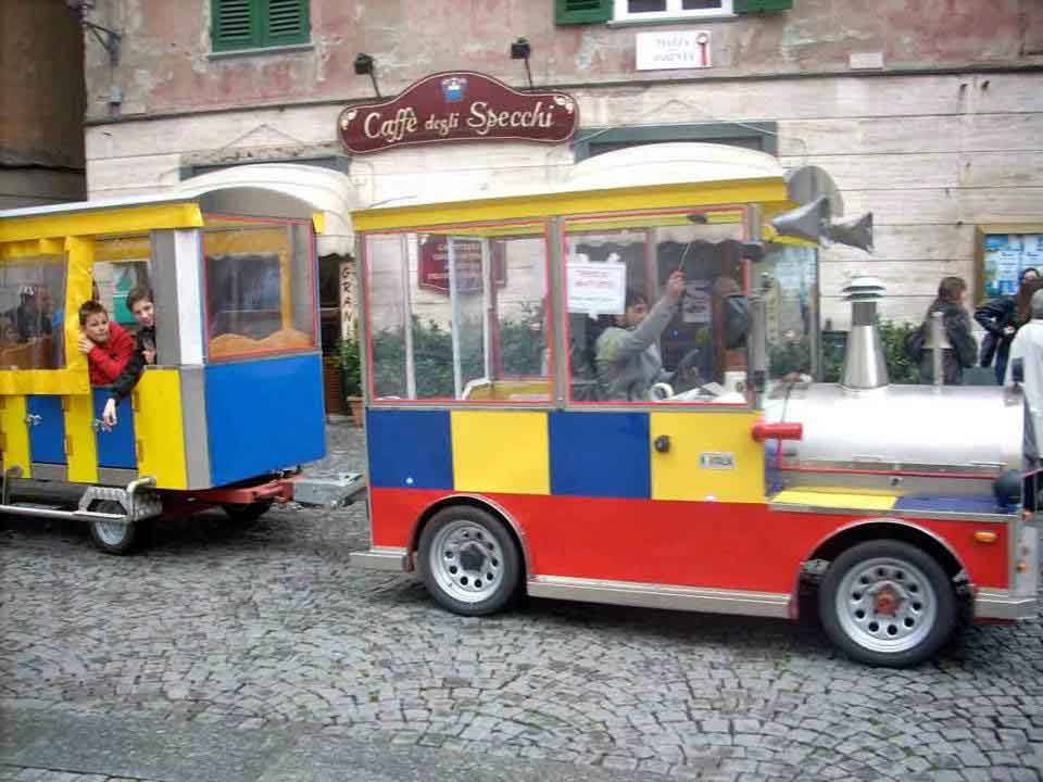 Trenino turistico multicolore su sampietrini davanti al Caffè degli Specchi