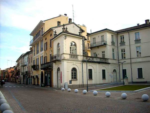 Cobblestone square with white stone spheres and cream historic buildings