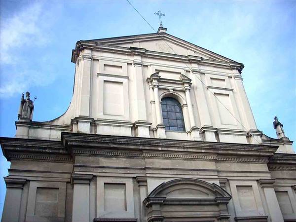 Baroque church facade in light stone with saint statues and cross
