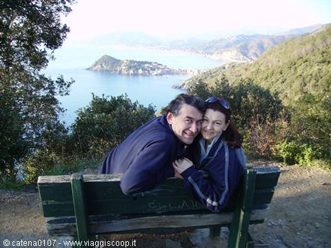 Couple hugging on green bench overlooking the sea of Sestri Levante